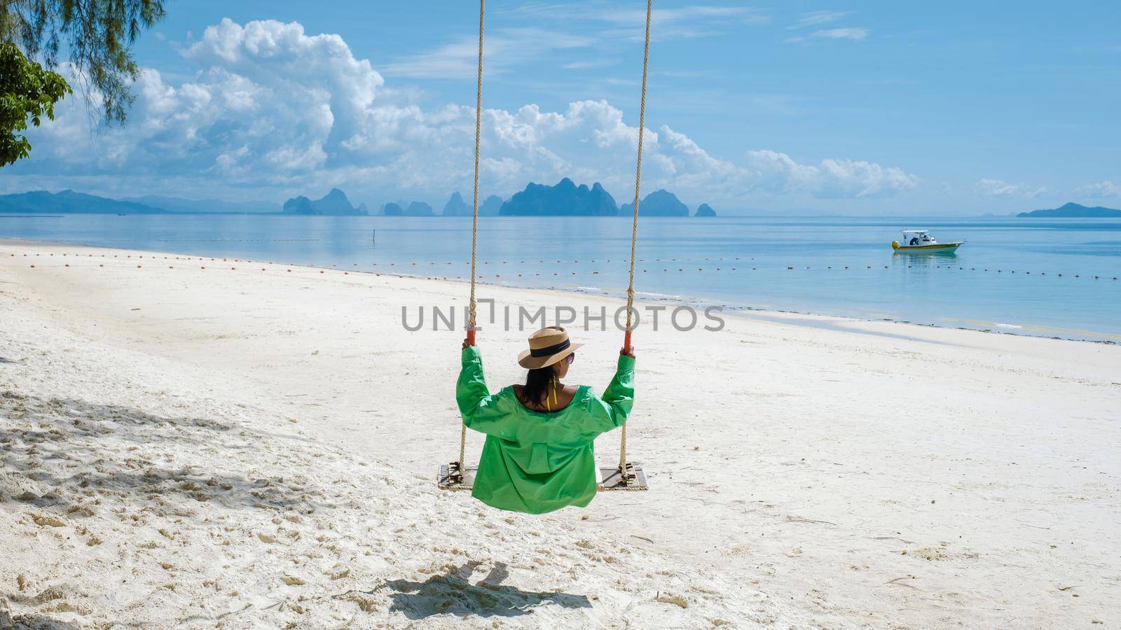 woman on the beach of the tropical Island Naka Island near Phuket Thailand, woman at a swing on the beach by fokkebok