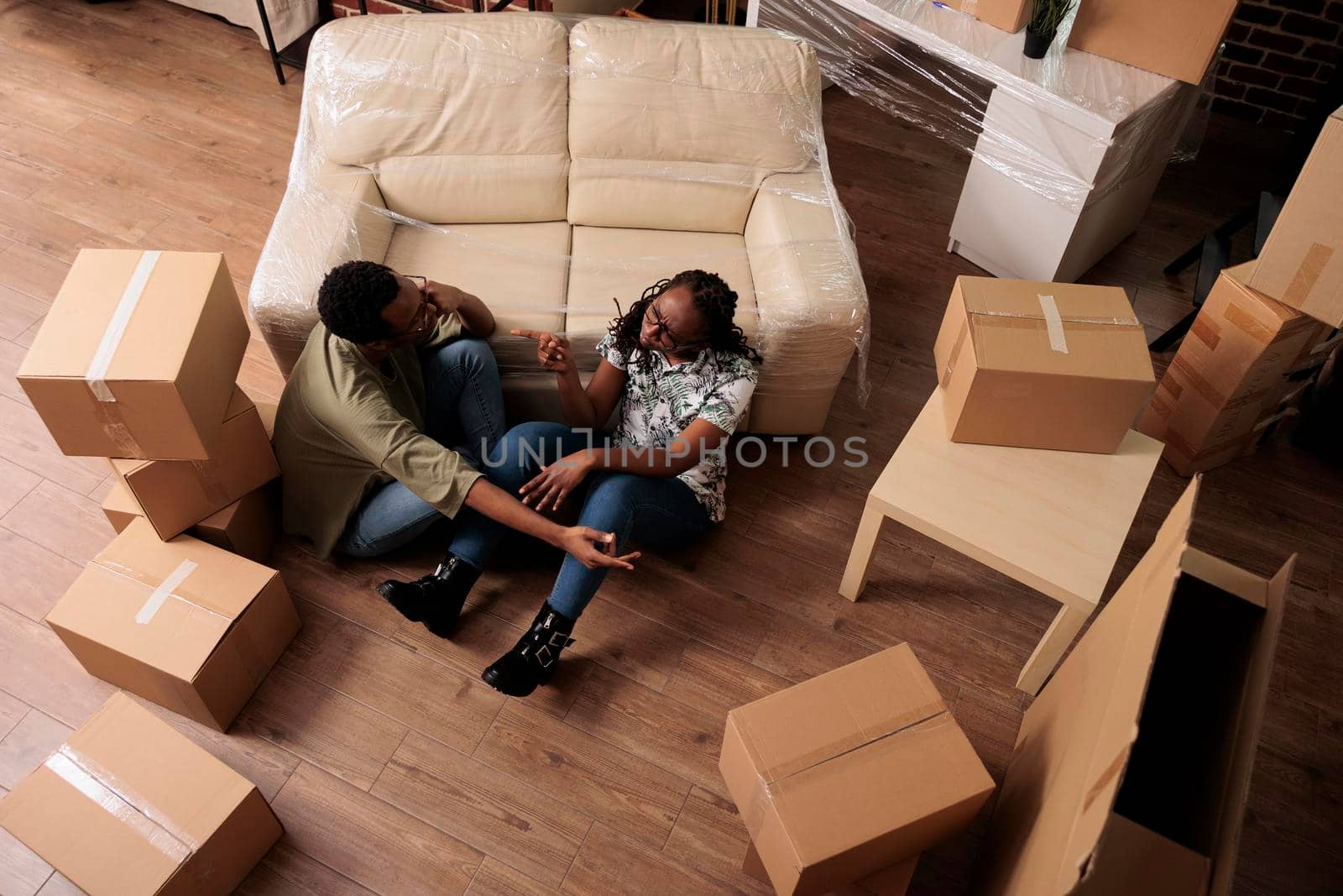 Romantic people relaxing together on living room floor, talking about decorations and future family. Enjoying relocation and taking break after moving in, relationship achievement. Top view of.