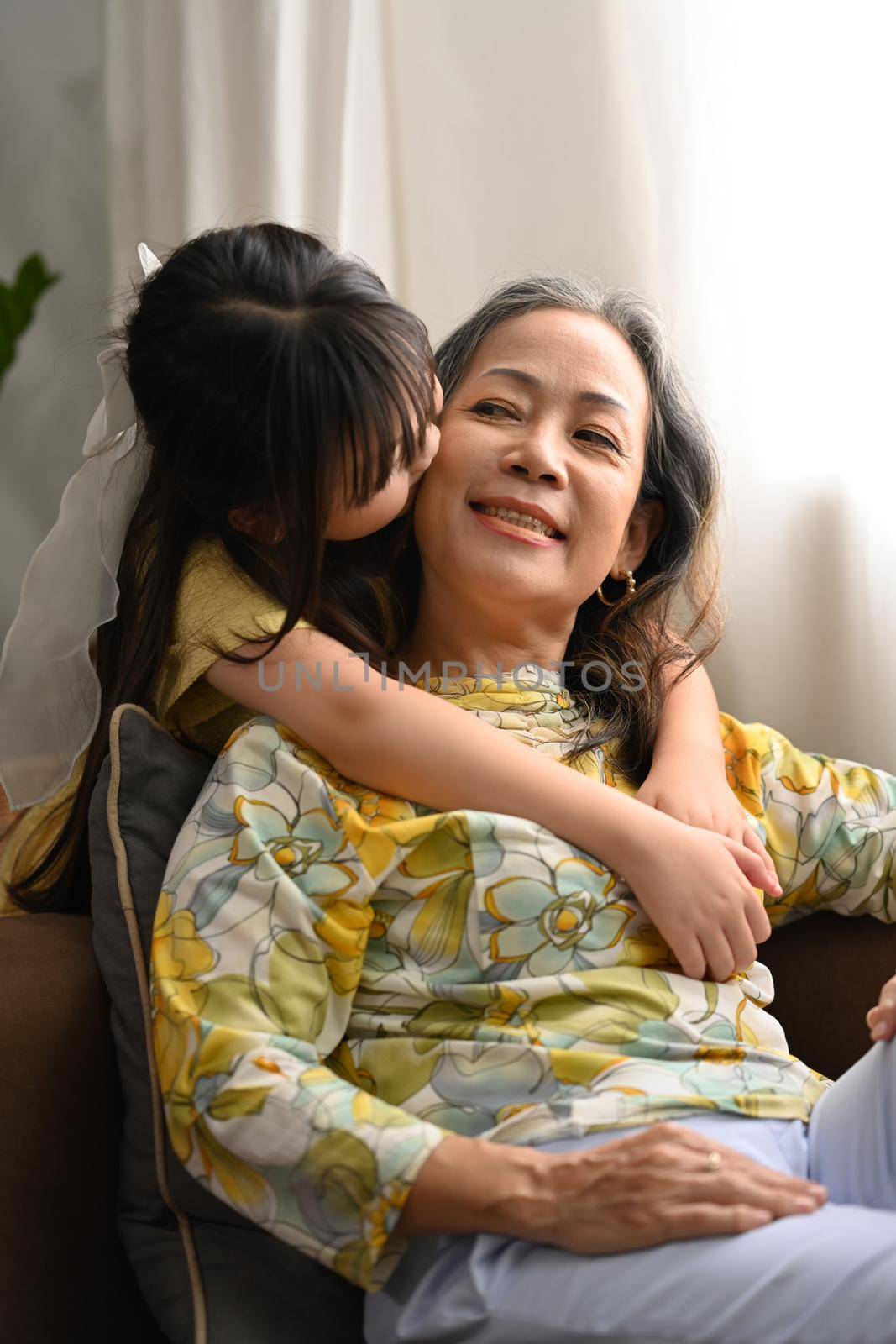 Cute little granddaughter hugging grandma, happy moment, best friend gratitude for love concept by prathanchorruangsak