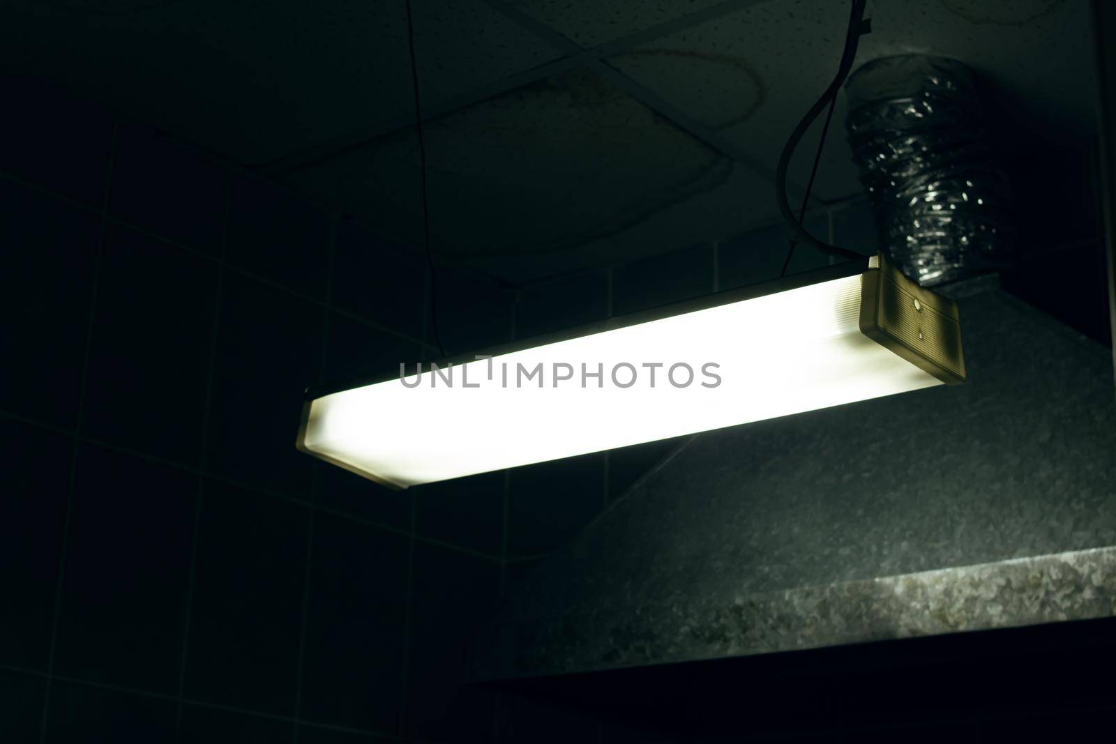 Old fluorescent lamp in a creepy dark room close up