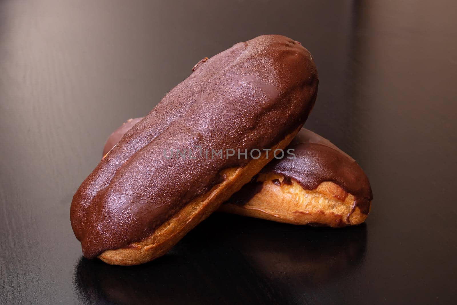 Two chocolate custard cakes on wooden table close up