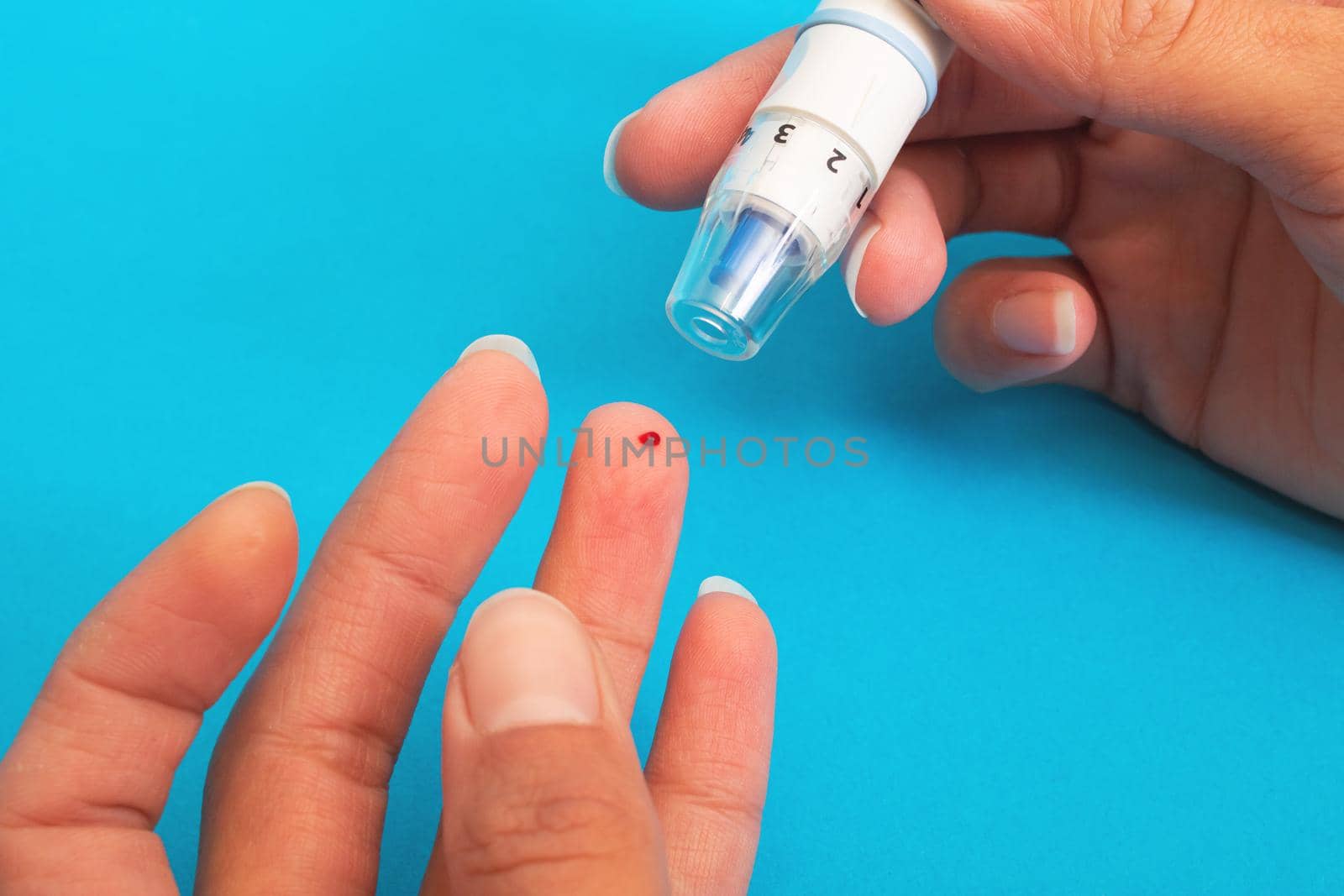 The lancet device pierces the finger close up