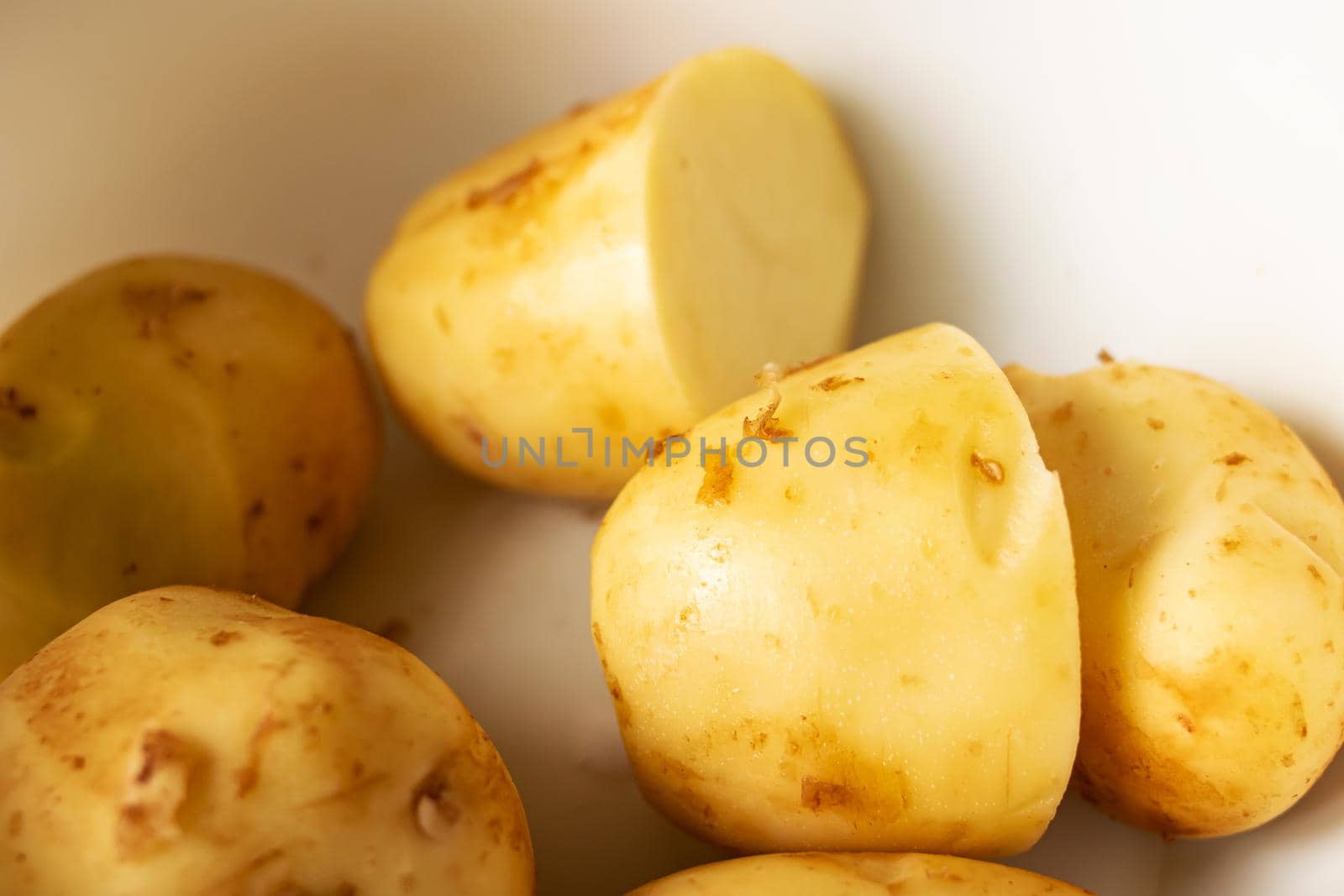 Yellow peeled potatoes in a bowl close up