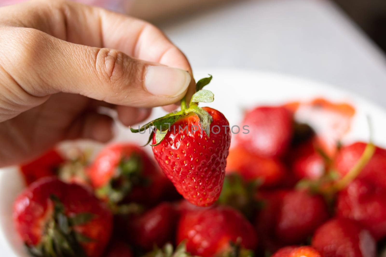 Heap of ripe red strawberries with green leaves close up