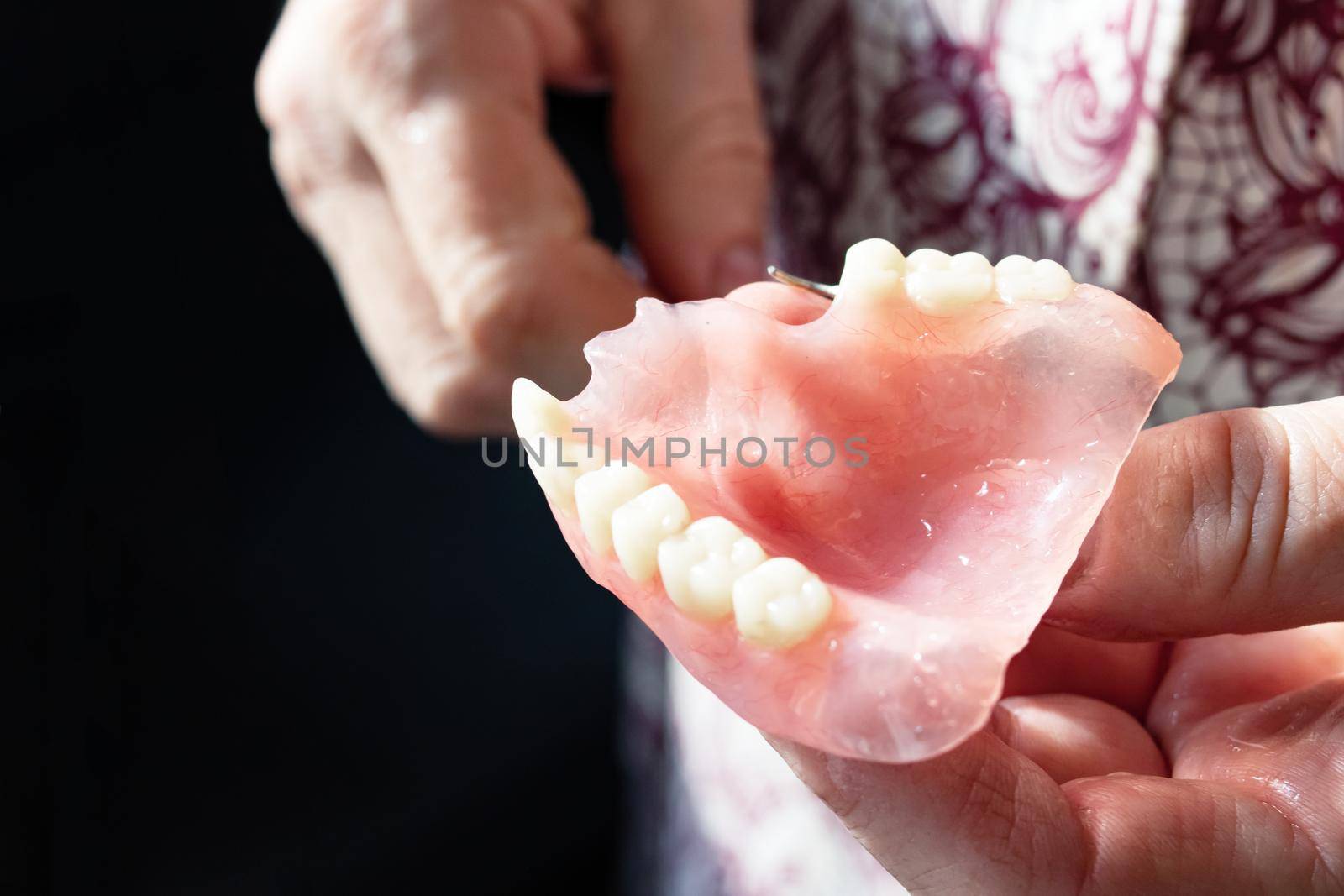 False jaw in womans hand close up, stomatology
