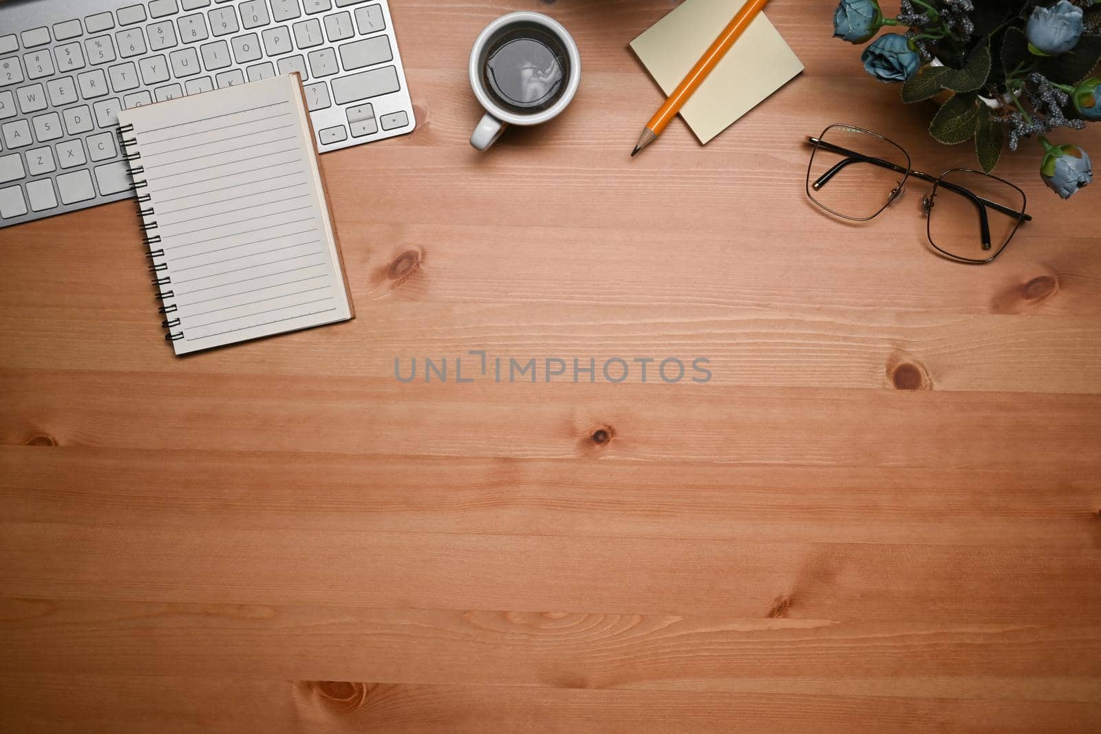 Flat lay empty notebook, coffee cup, glasses and sticky notes on wooden table. by prathanchorruangsak