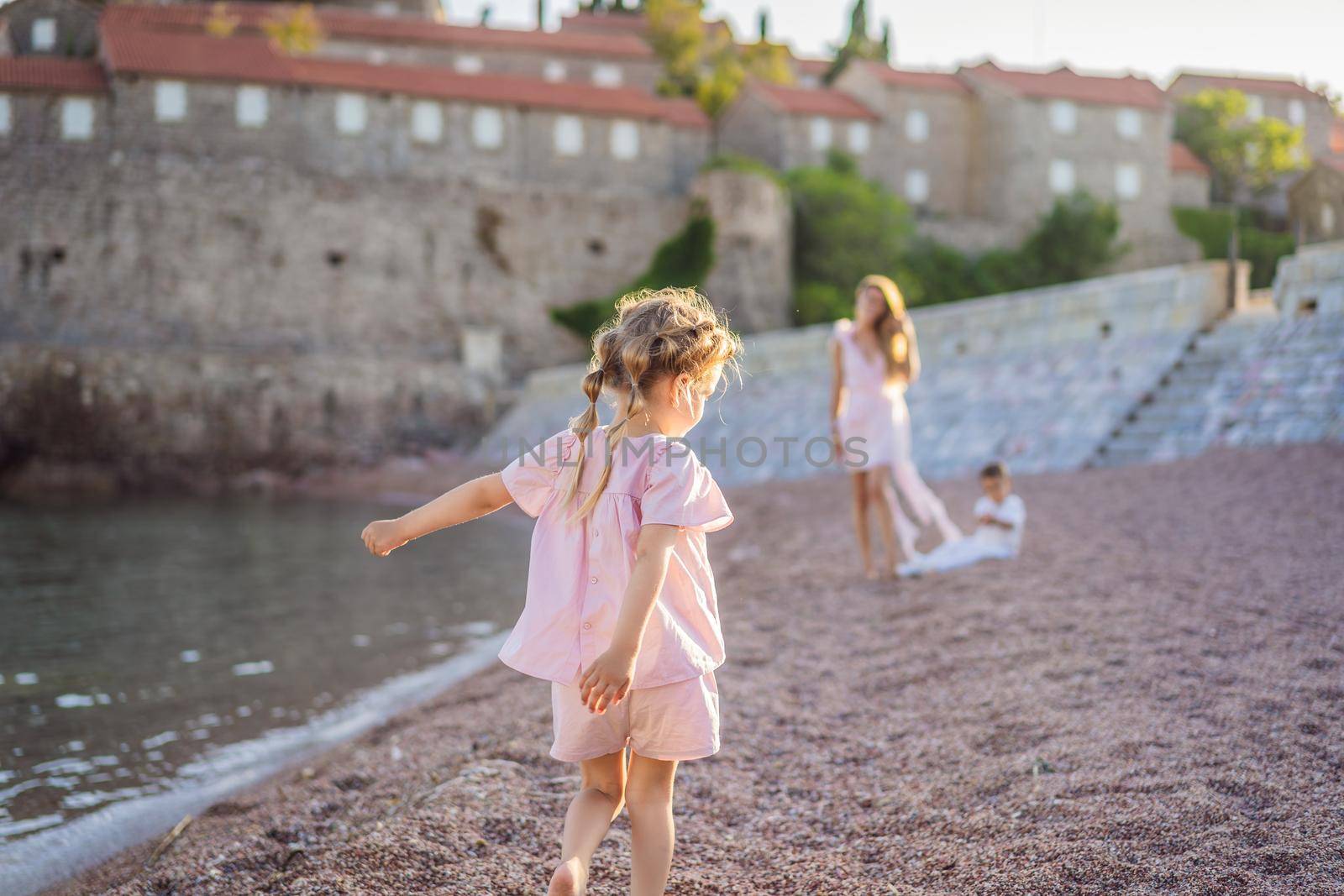 Mother and two children daughter and son tourists on background of beautiful view St. Stephen island, Sveti Stefan on the Budva Riviera, Budva, Montenegro. Travel to Montenegro concept.