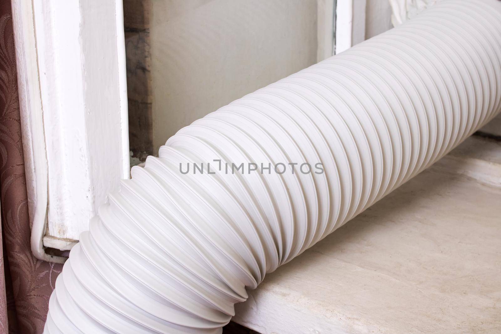 Corrugated pipe from the air conditioner on the windowsill close up