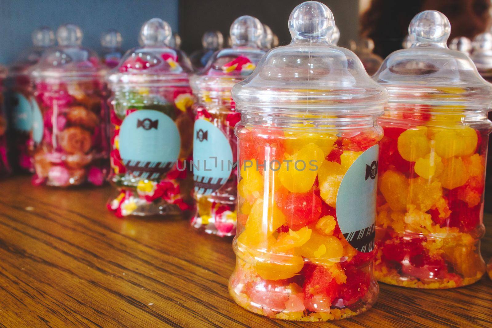 Colorful candies in plastic jars on a shelf in a sweet shop