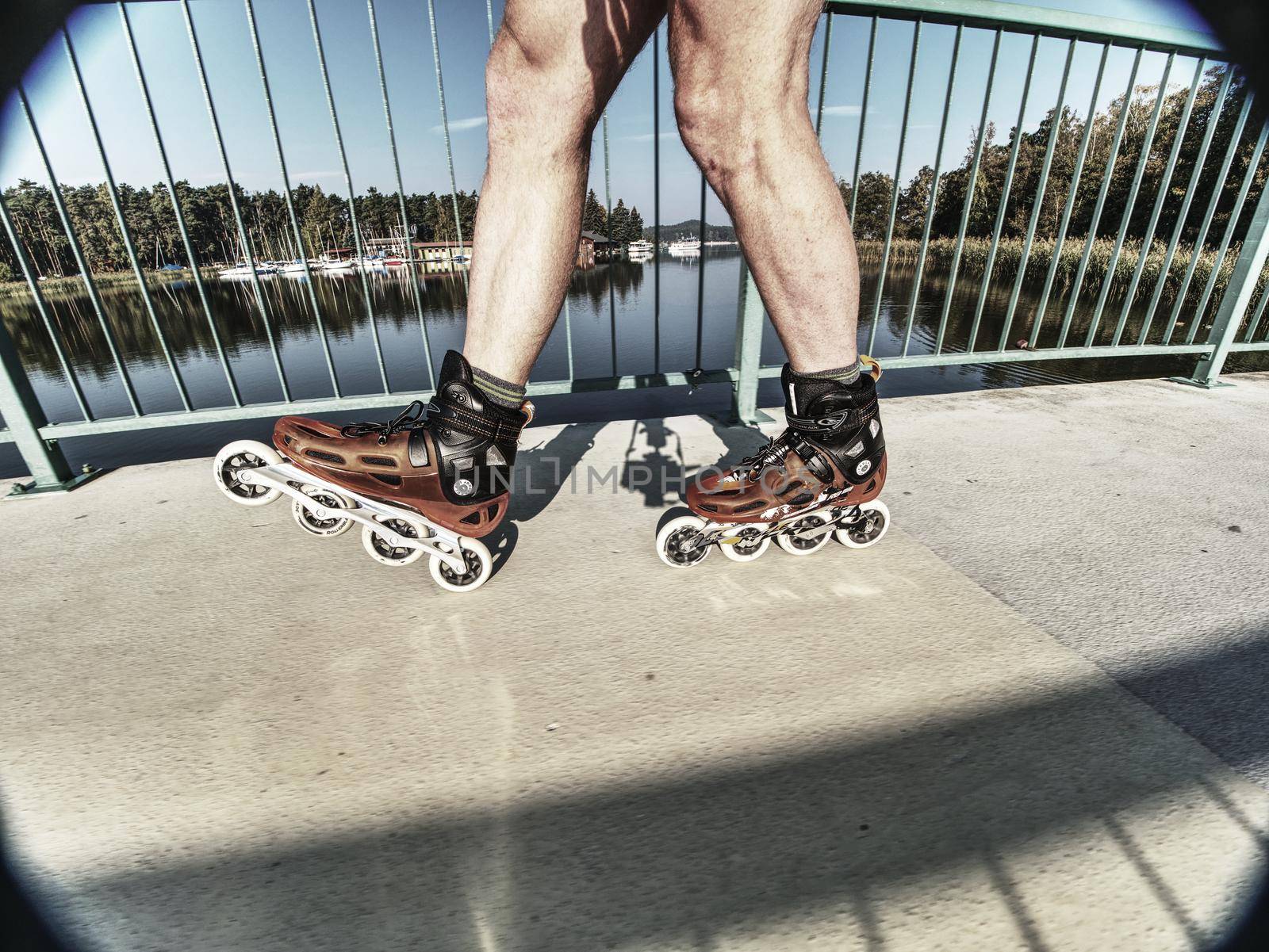 Man roller skater in speed hard shell skates.  Man try trick on the pathway by rdonar2
