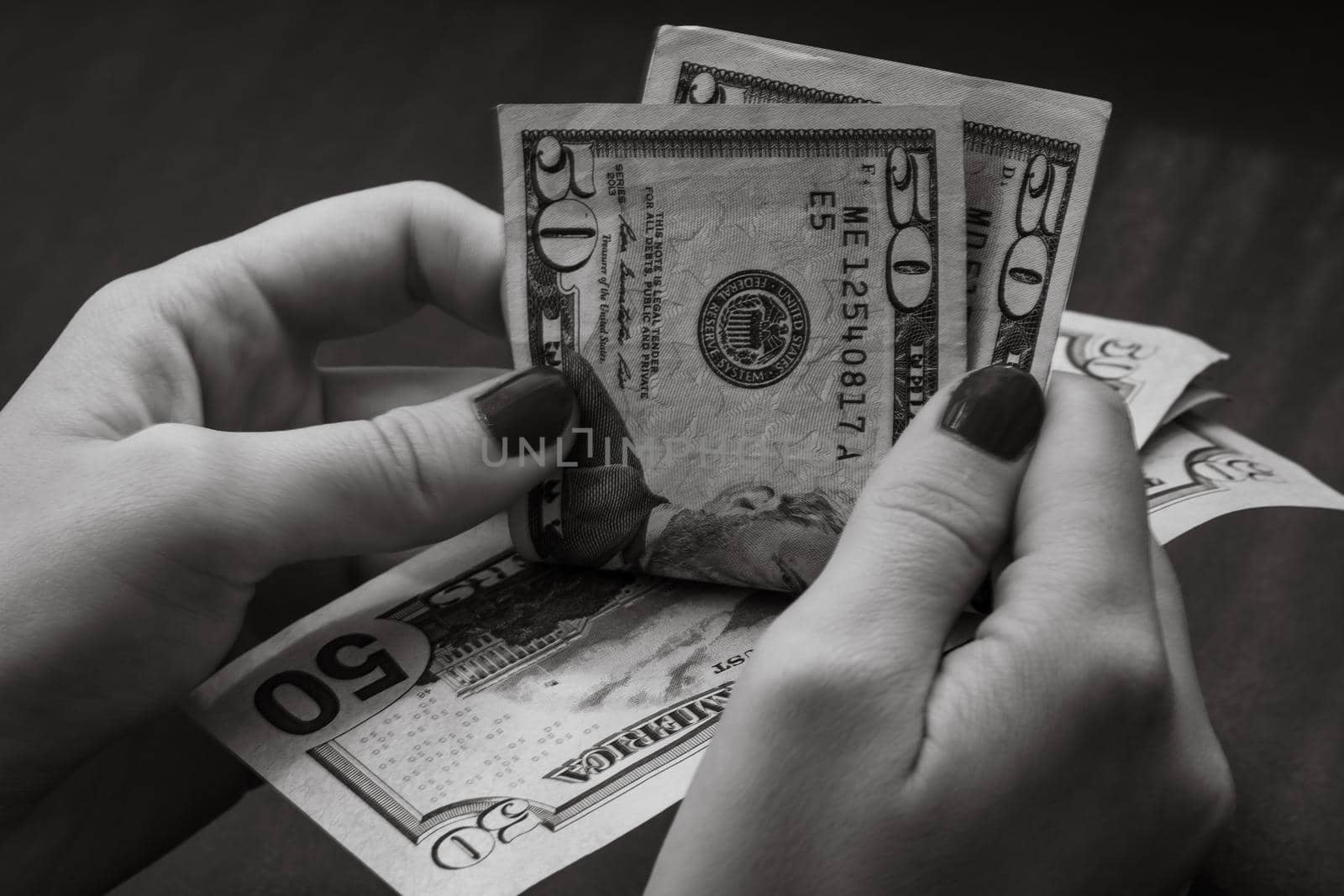 Woman counting money, counting dollars close up