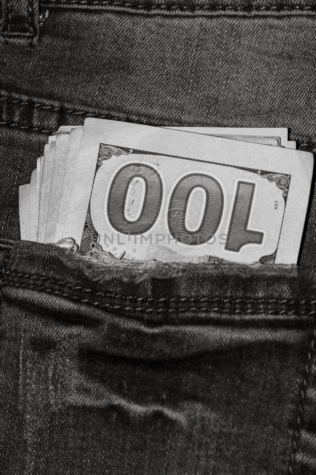 Banknotes, money in a jeans pocket, close up. Money stick out of the jeans pocket, finance and currency concept. Concept of rich people, saving or spending money. by vladispas