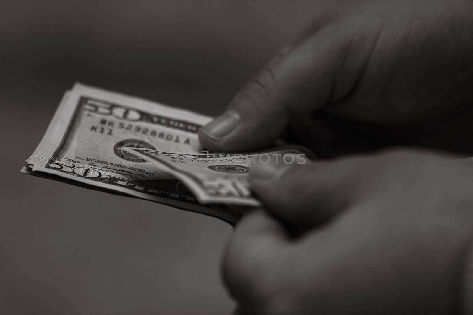 Selective focus on detail of USD banknotes. Counting or giving United States Dollars banknotes. World money concept, inflation and economy concept by vladispas