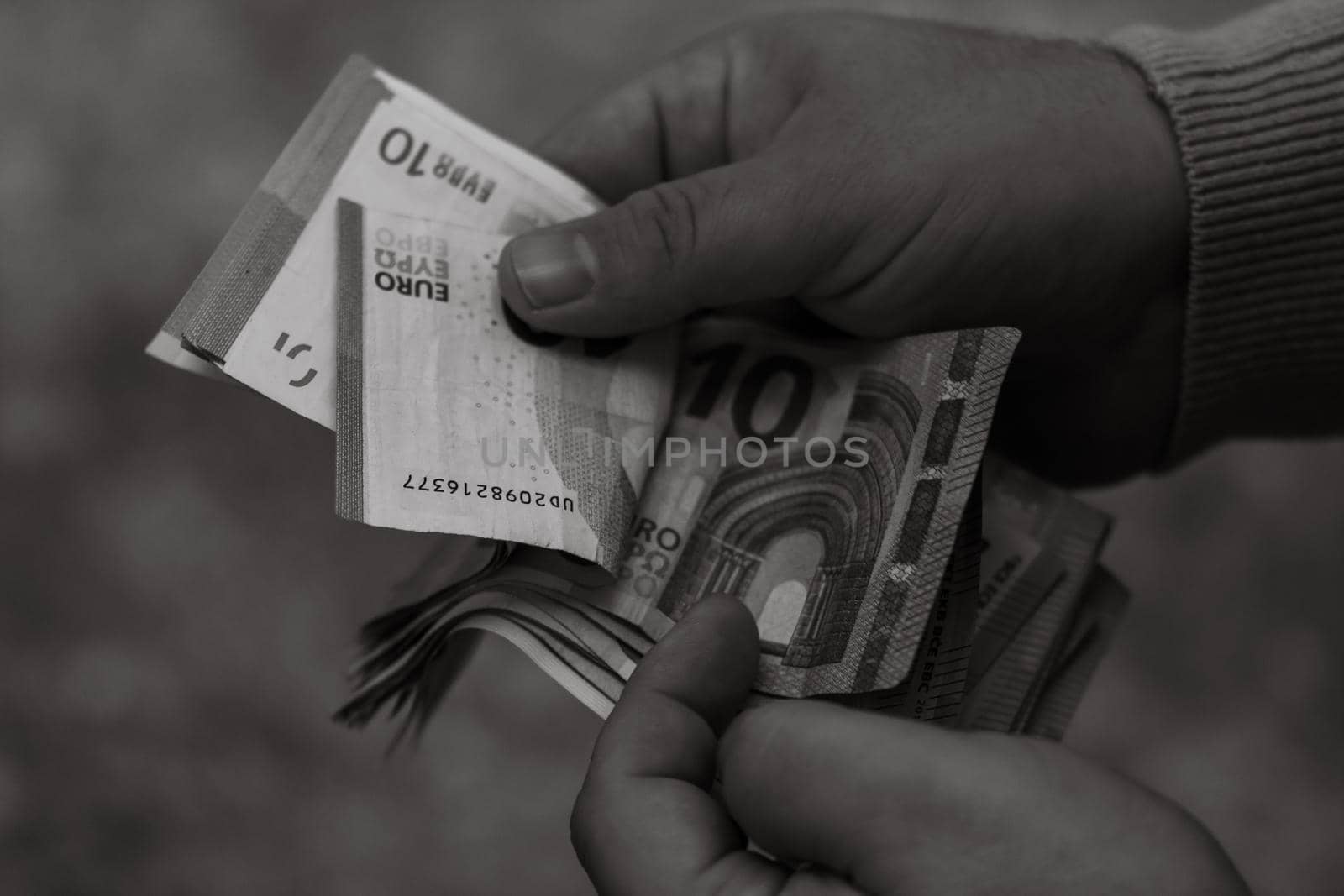 Selective focus on detail of EURO banknotes. Counting or giving EURO banknotes. World money concept, inflation and economy concept by vladispas
