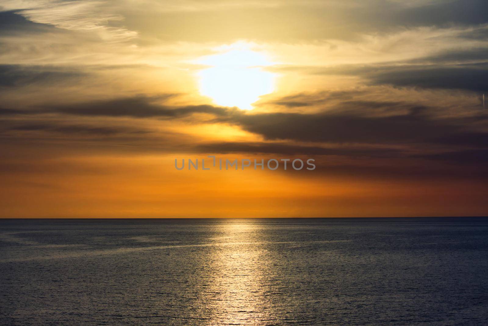 Stunning sunset in a dramatic sky above a serene, calm ocean