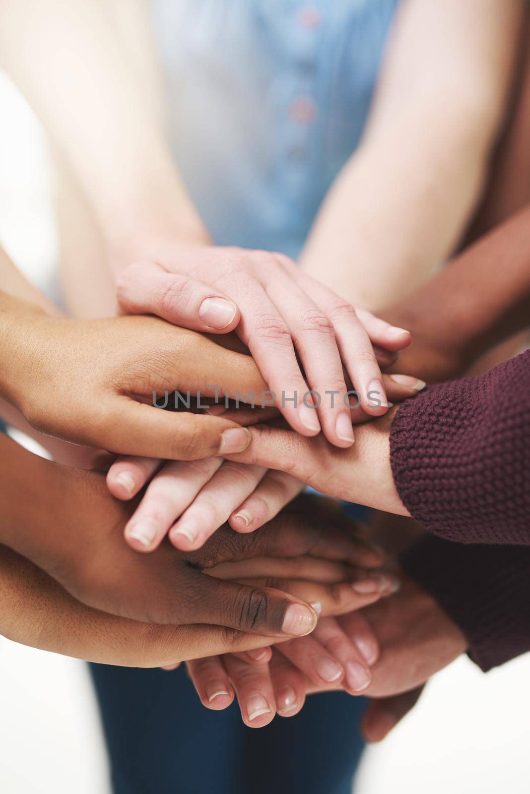 Strength in numbers. Cropped shot of a group people putting their hands together in unity. by YuriArcurs