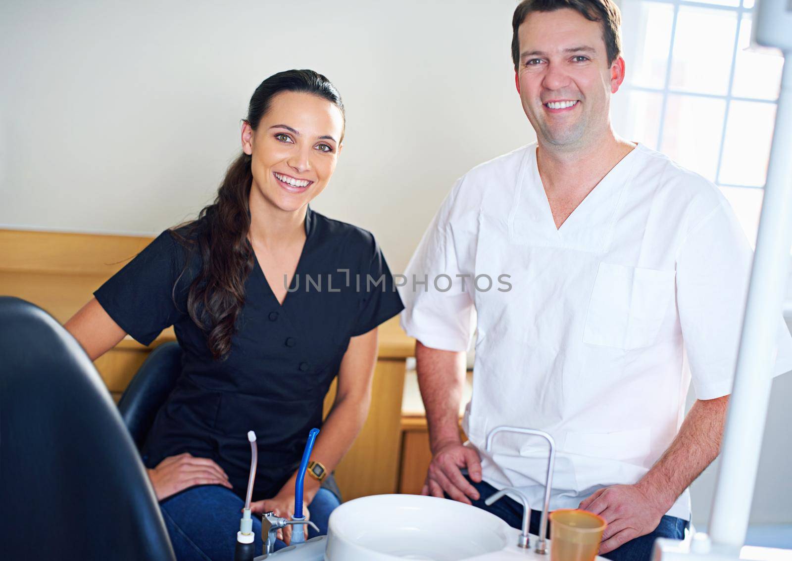 Cropped portrait of a dentist standing with his assistant.