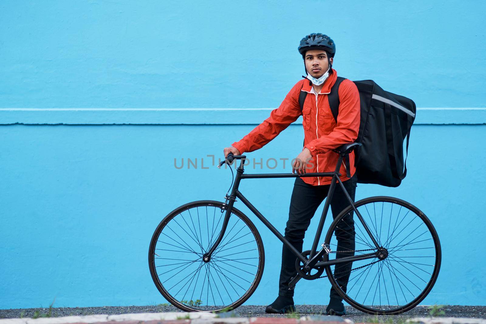 Skipping traffic to get your package delivered faster. Shot of a delivery man out with his bicycle. by YuriArcurs