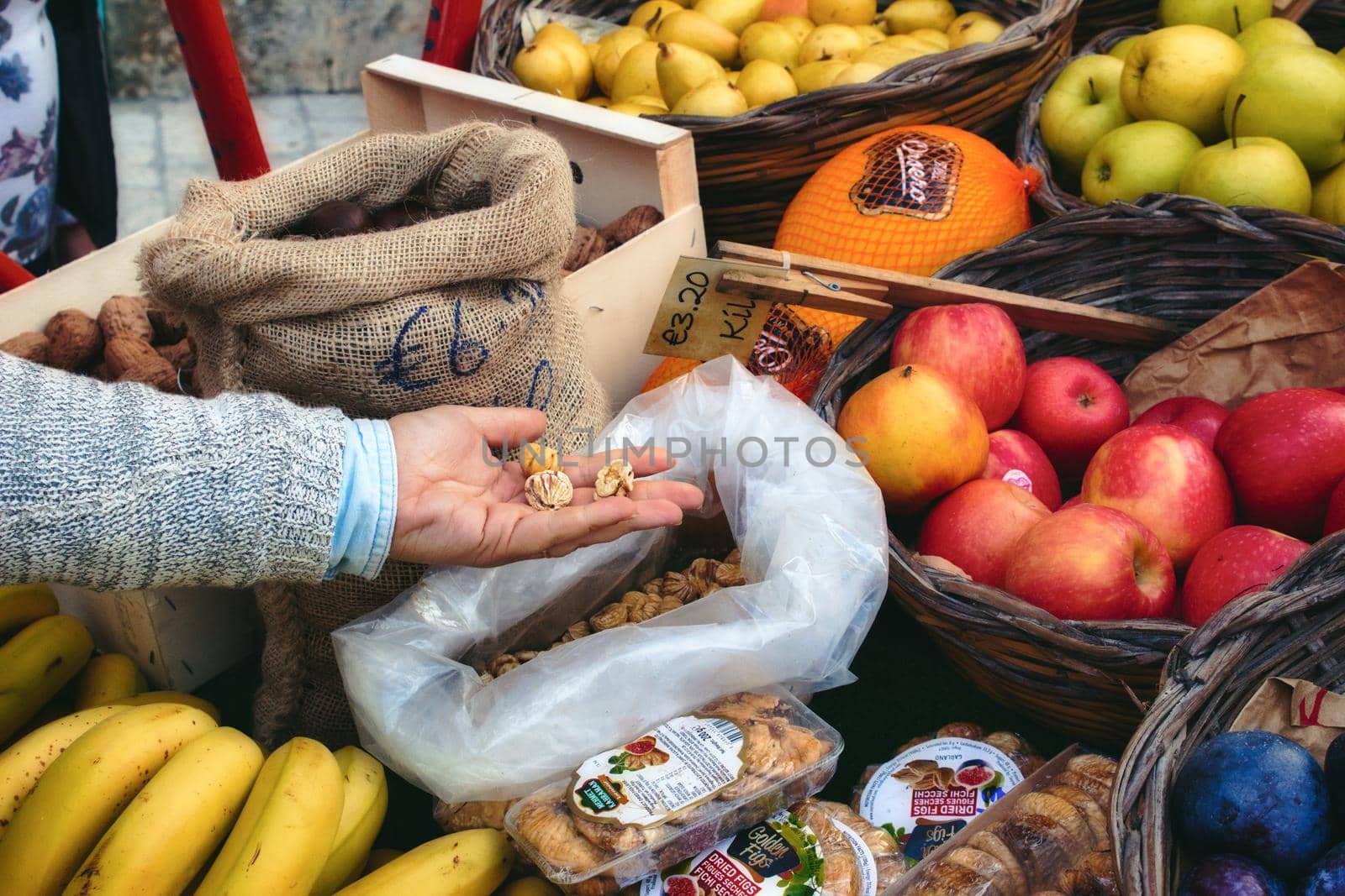 Market vendor cart with varied fruit in wicker baskets and sacks
