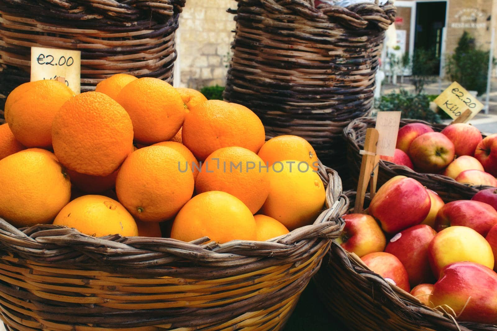 Market vendor cart with varied fruit in wicker baskets