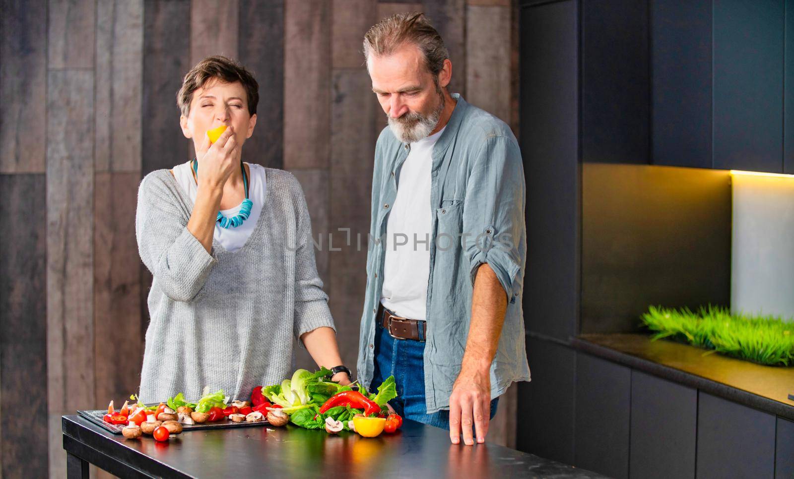 aged couple in the kitchen preparing food