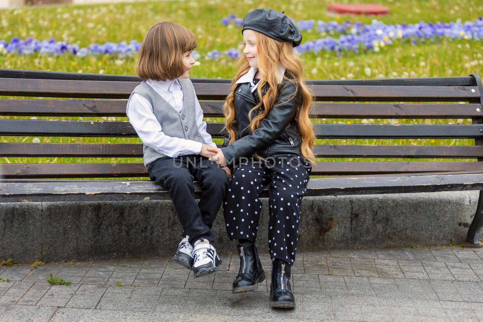 children sit on a bench in the city and talk