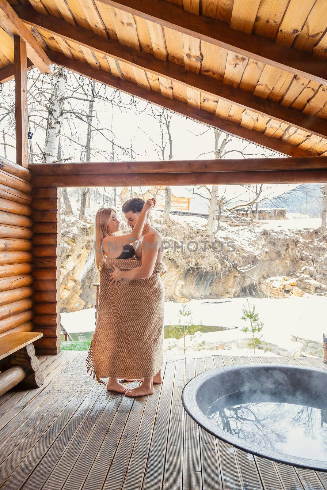 young couple hugging near a vat of water