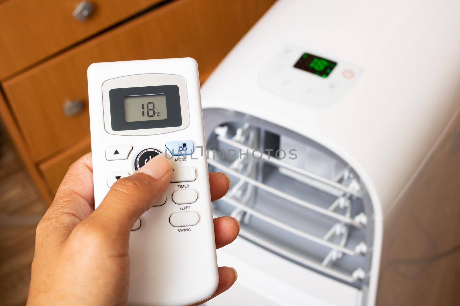 Air conditioner remote control in hand close up