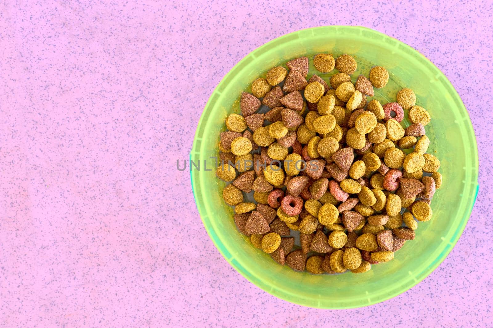 a round, deep dish or basin used for food or liquid. Green plastic bowl with cat dog tasty healthy food on a pink background