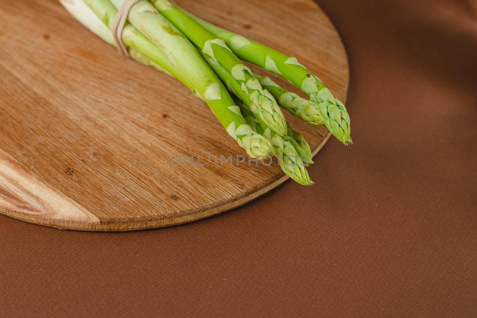 branches of fresh green asparagus on a wooden background, top view