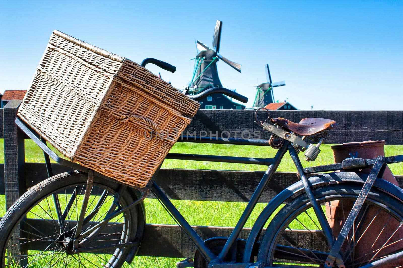 Bicycle with windmill and blue sky background. Scenic countryside landscape close to Amsterdam in the Netherlands.  by Perseomedusa