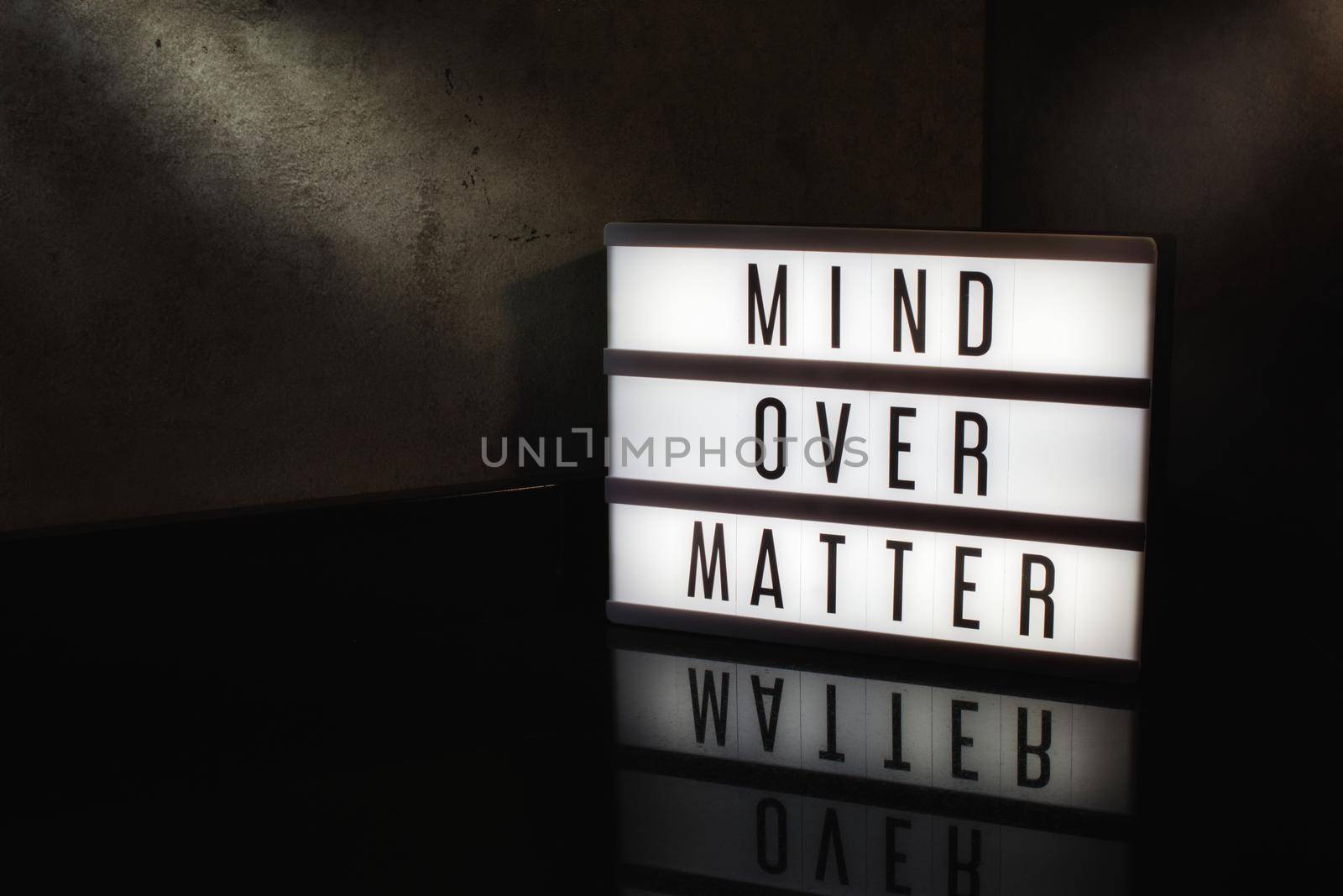 Mind over matter motivational message on a light box in a cinematic moody background