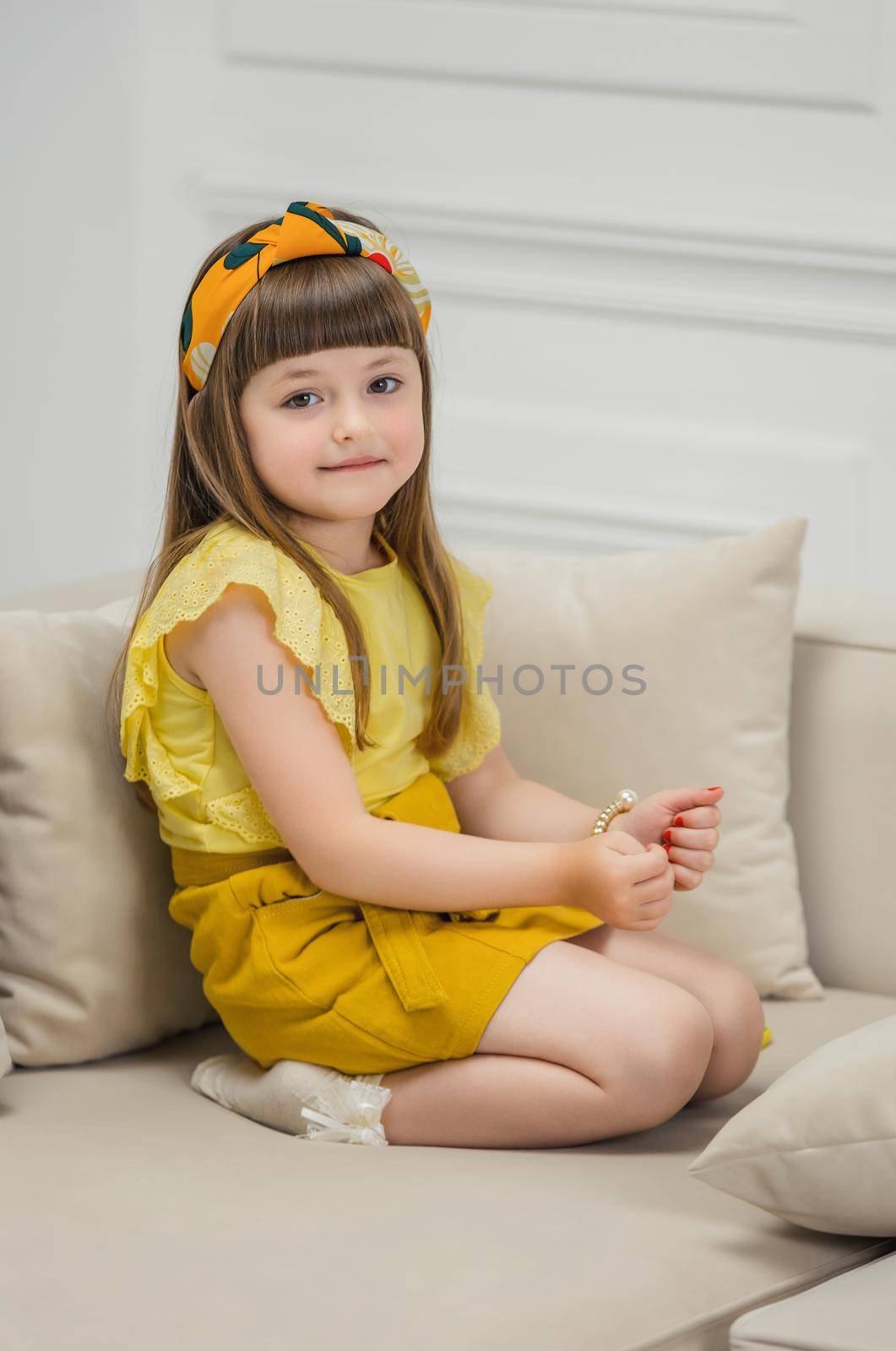 a girl in a yellow suit sits on sofas