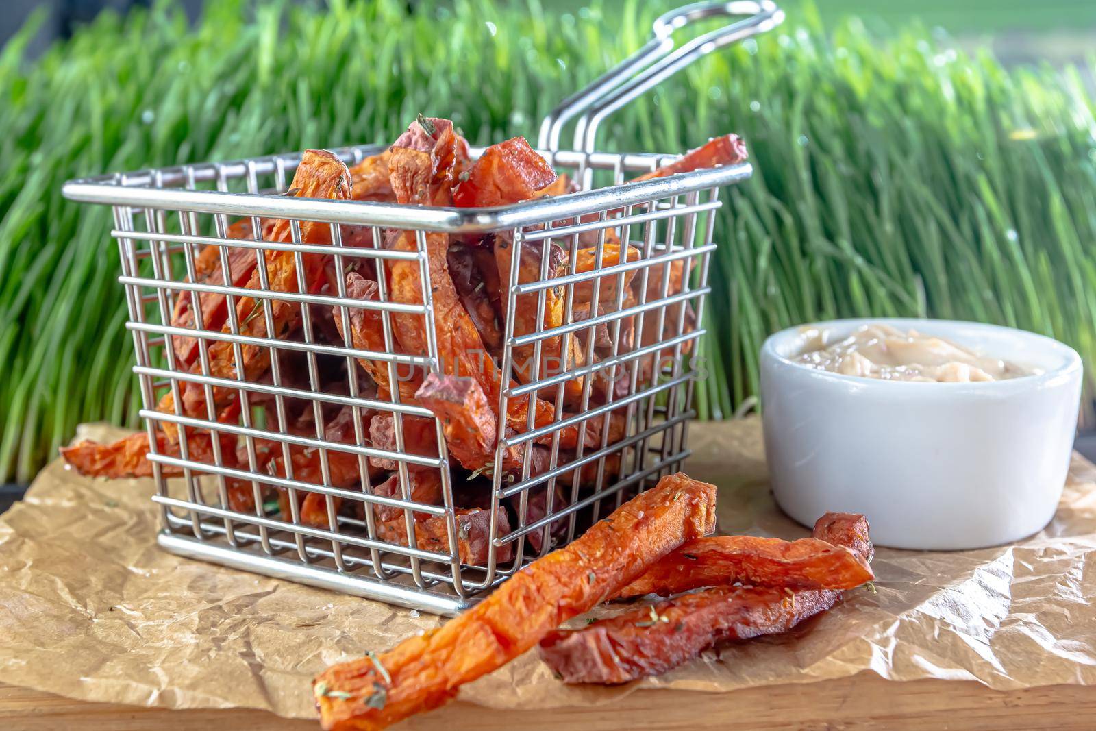 deep fried potato fries sweet potato in a fat frying basket, unhealthy and junk food concept by Milanchikov
