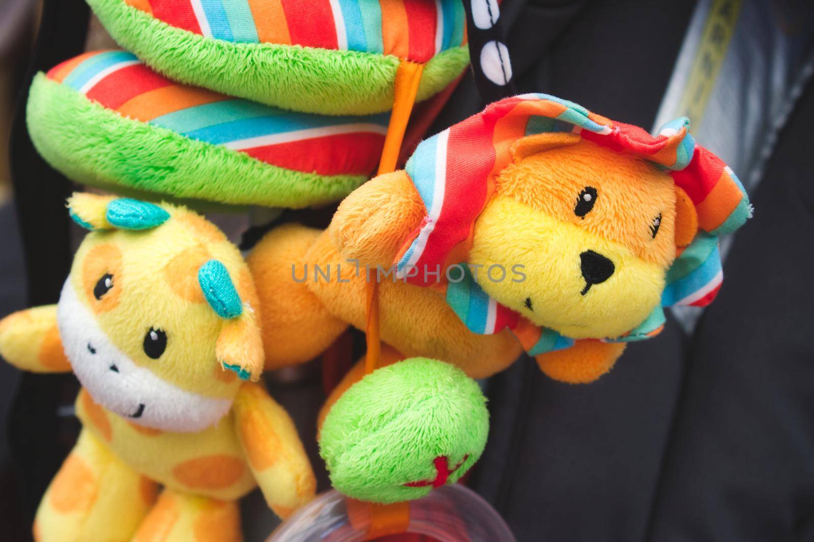 Soft cuddly toys hanging from a baby's pushchair