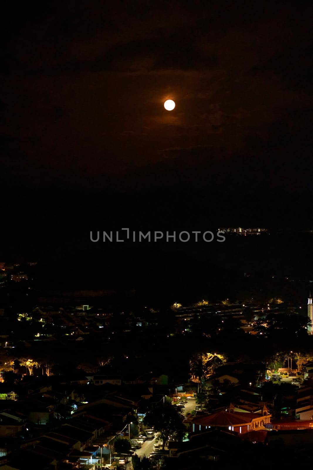 bright full moon in the night sky over the city.