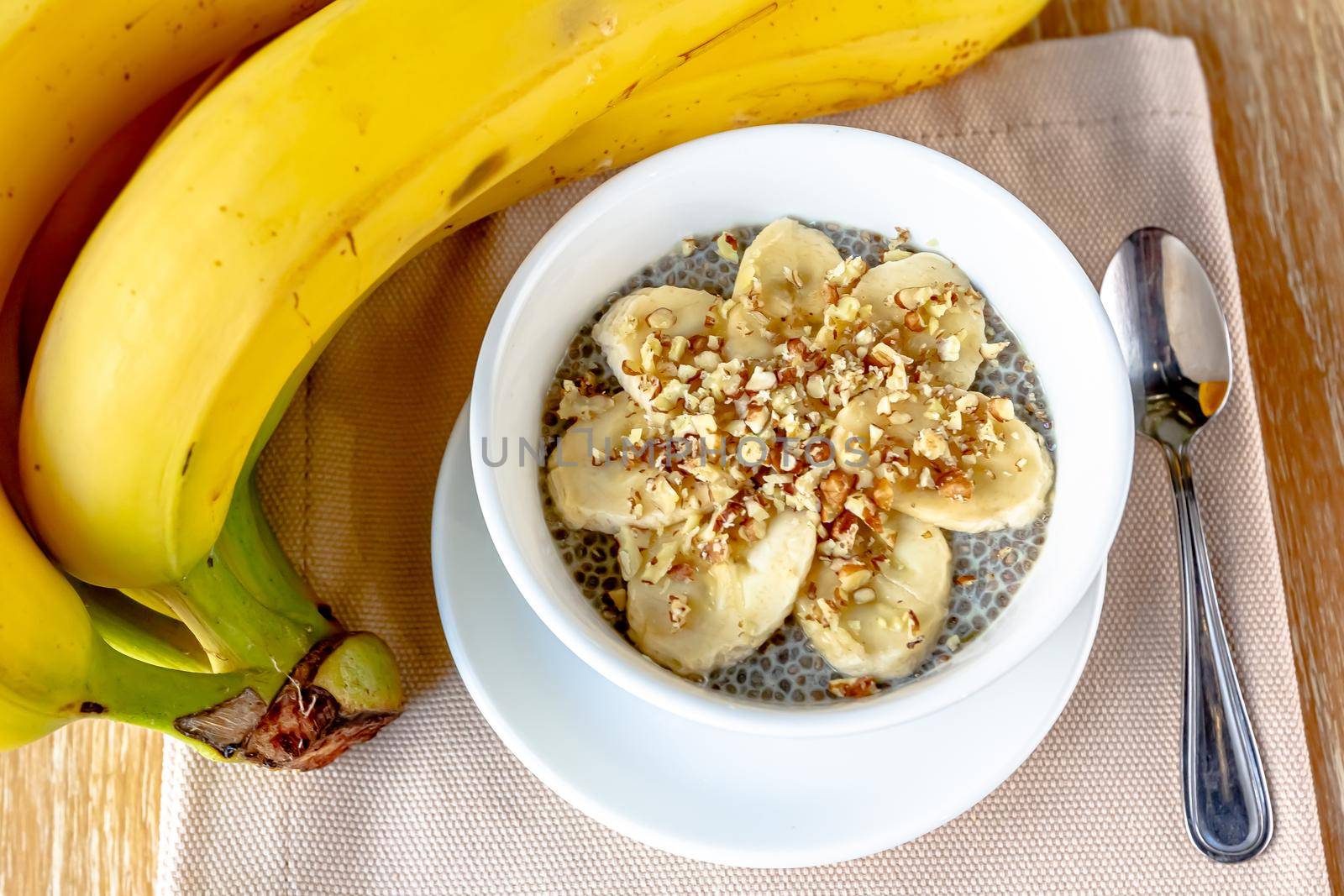 Dessert bowl of tasty chia seed pudding with banana on white background.