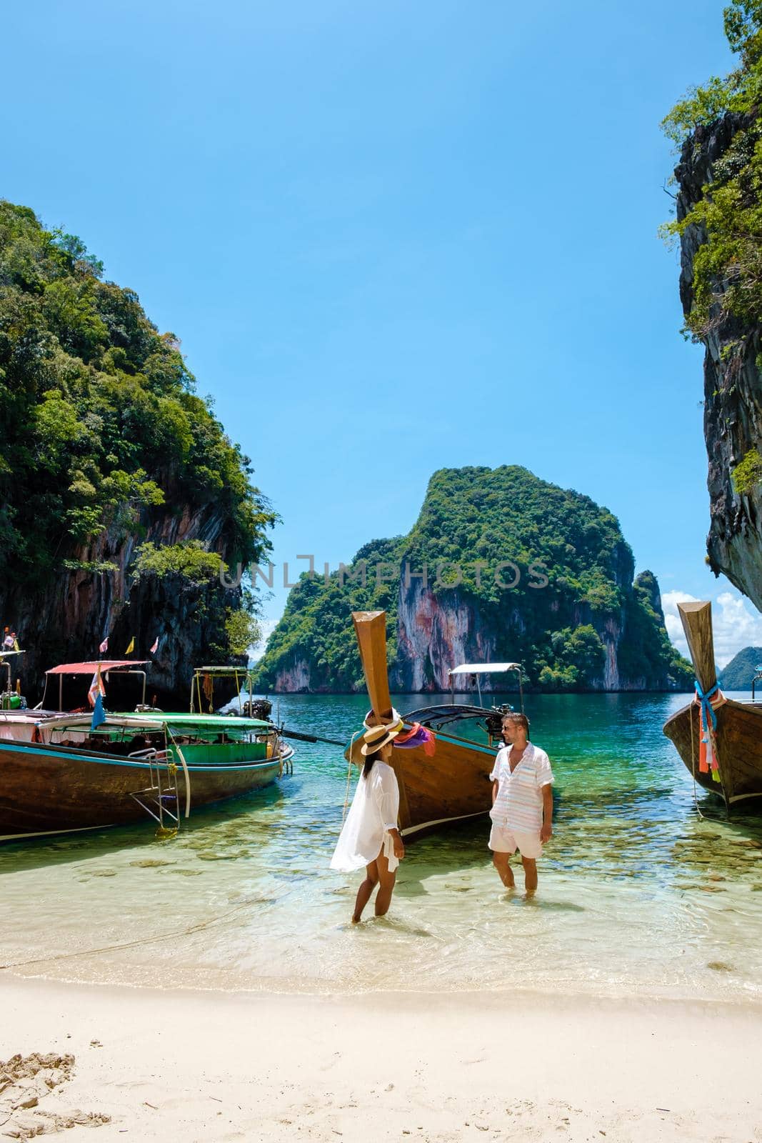 Koh Lao Lading near Koh Hong Krabi Thailand, beautiful beach with longtail boats, couple European men and Asian woman on the beach by fokkebok