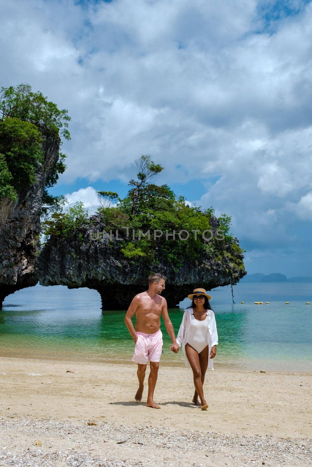Koh Phakbia Island is near Koh Hong Krabi, a beautiful white sandy beach in Krabi Thailand. Young Asian woman and European men on the beach.