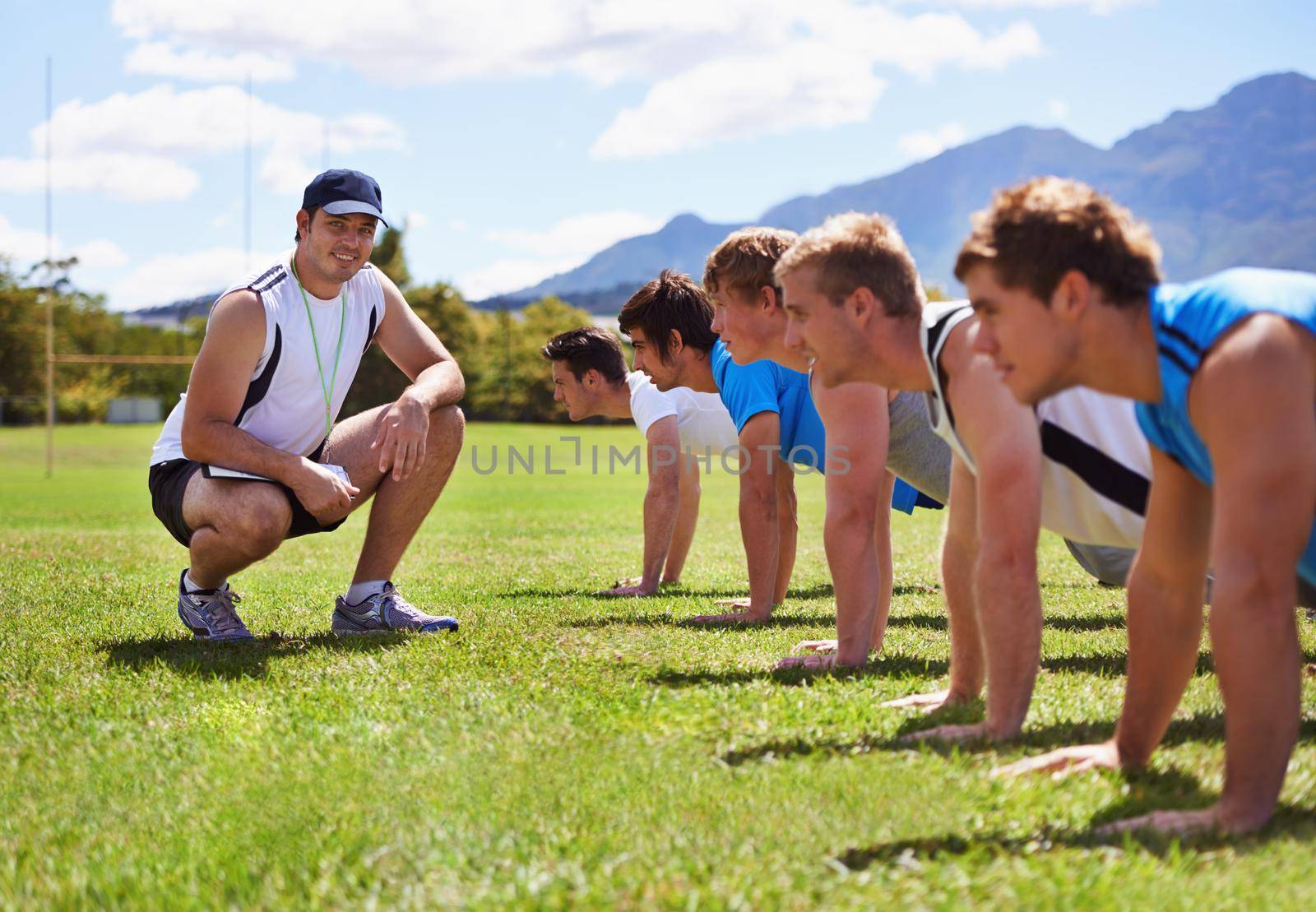Young sportsmen training outdoors with a coach.