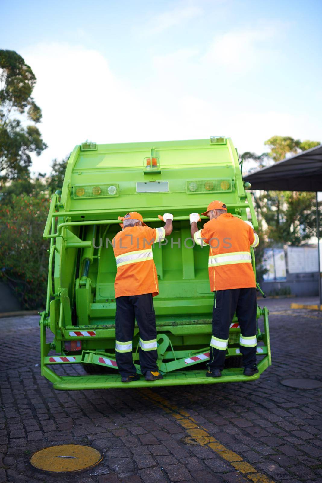 Garbage collection day. Cropped shot of a garbage collection team at work. by YuriArcurs