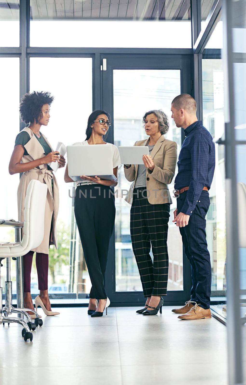 Shot of a team of colleagues using modern technology during an informal meeting.