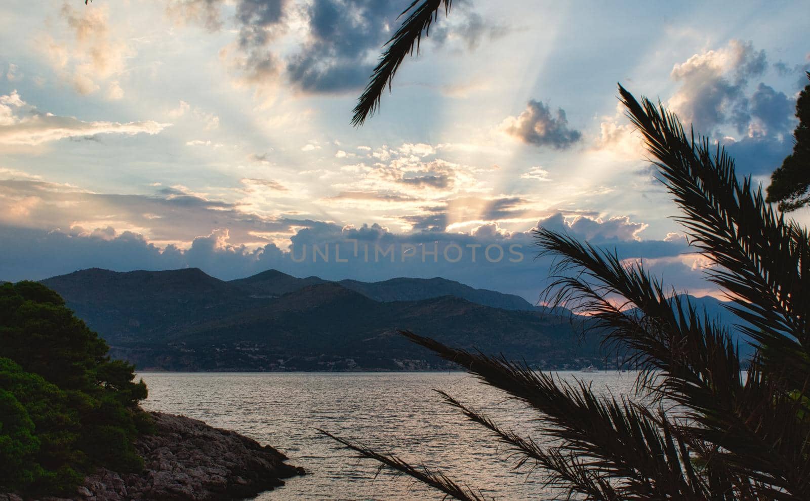 Beautiful sunset with golden rays breaking through clouds on a Mediterranean island