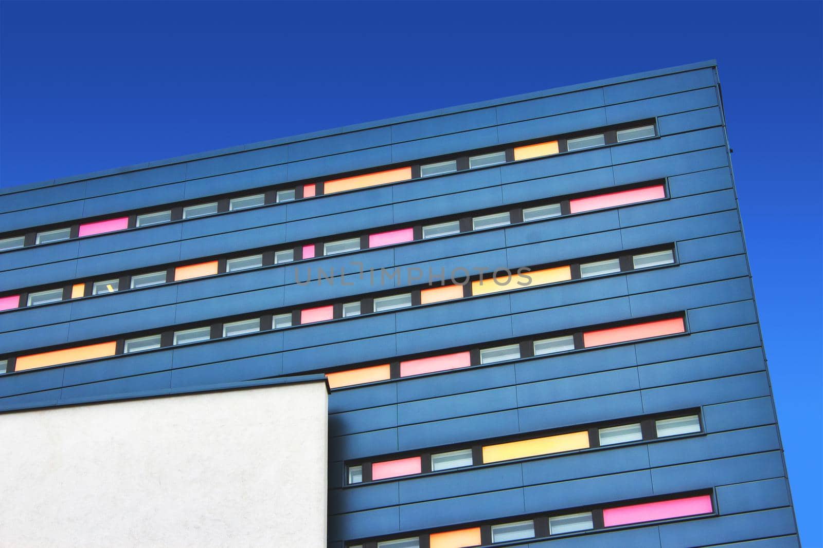 Modern design office block with colorful facade against a blue sky background