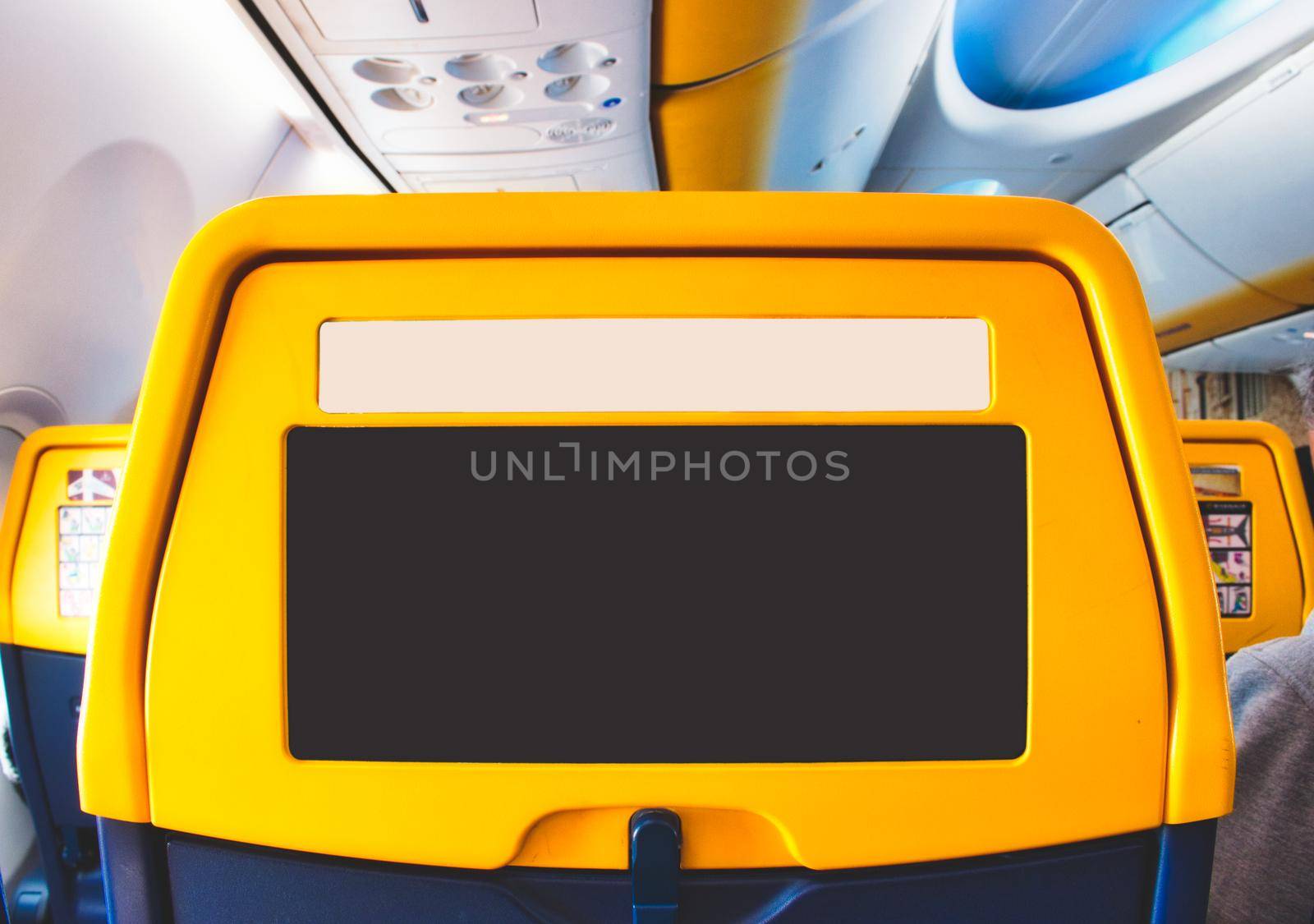 Back of a passenger seat on a commercial airline plane with empty area for advertising copy space