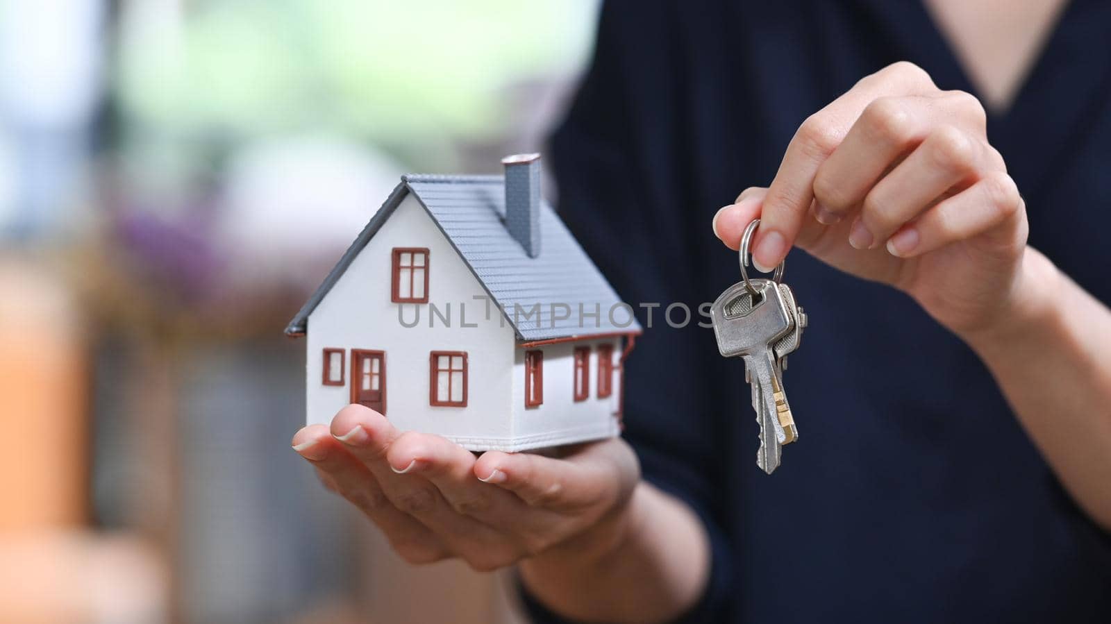 Real estate agent or financial advisor holding small house model and keys. Real estate investors, purchase and mortgage concept by prathanchorruangsak