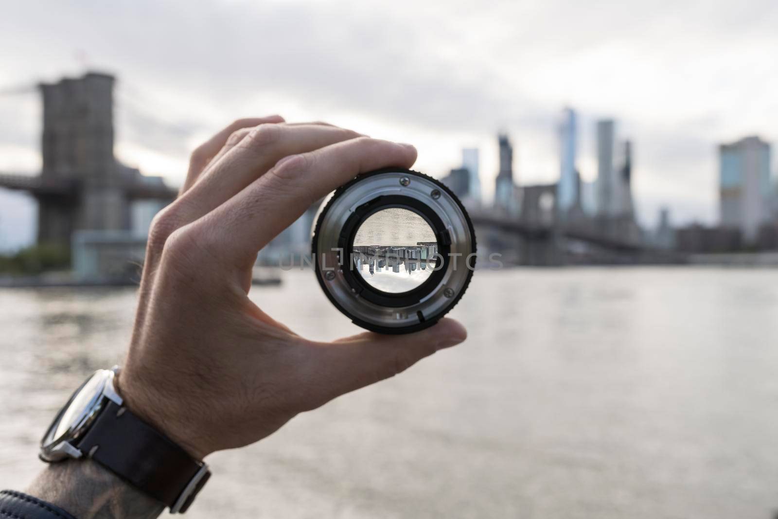 Hand holding a lens against New York skyline