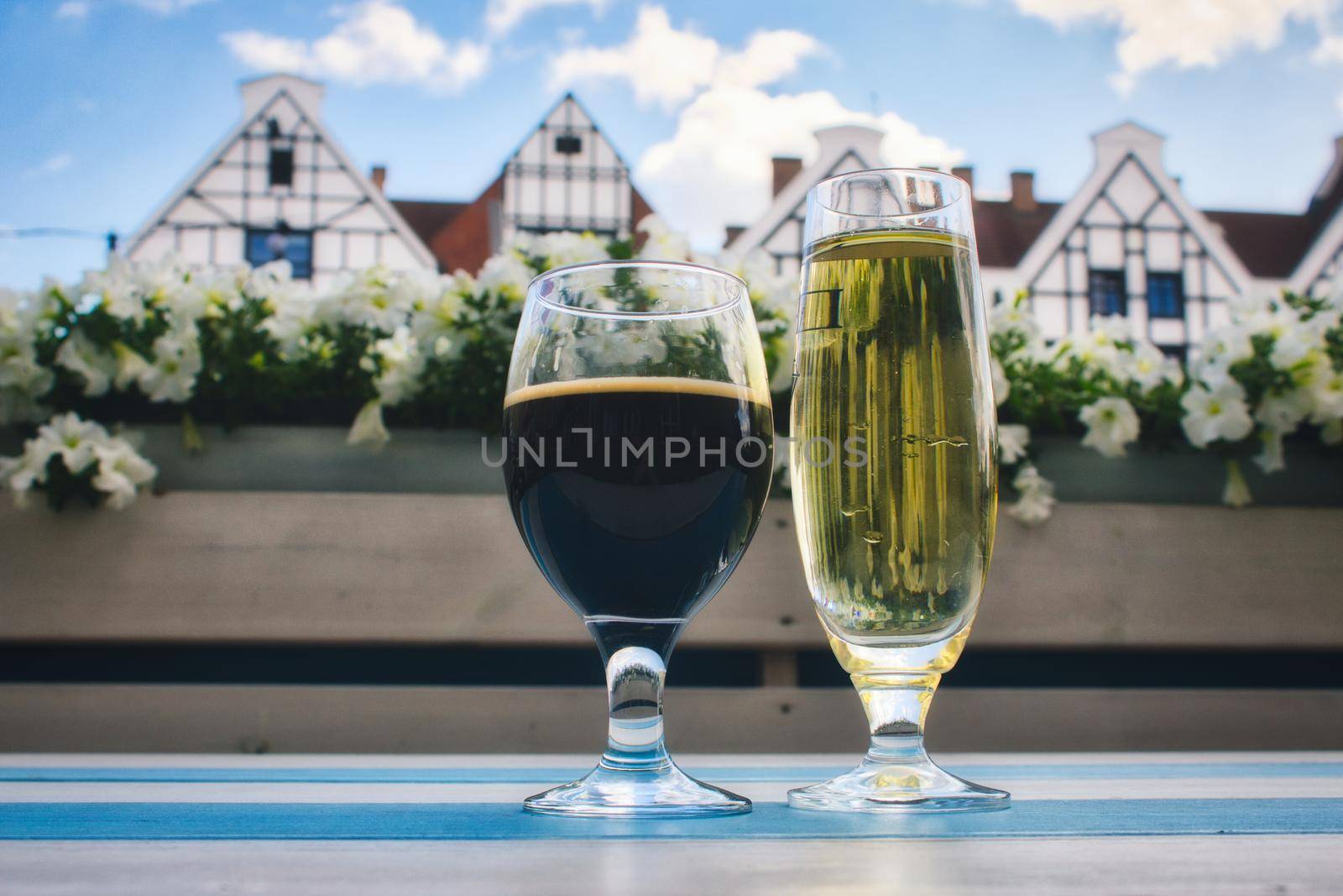 Close-up of summer drinks of stout and cider in fancy glasses outside on a table