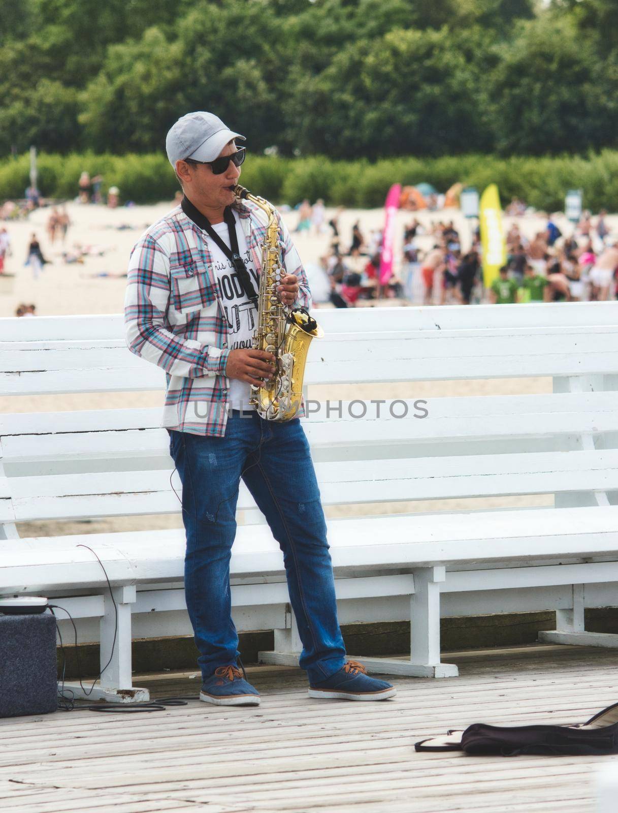 Sopot / Poland - August 3 2019: A saxophonist busker blowing the sax for money on the pier by tennesseewitney