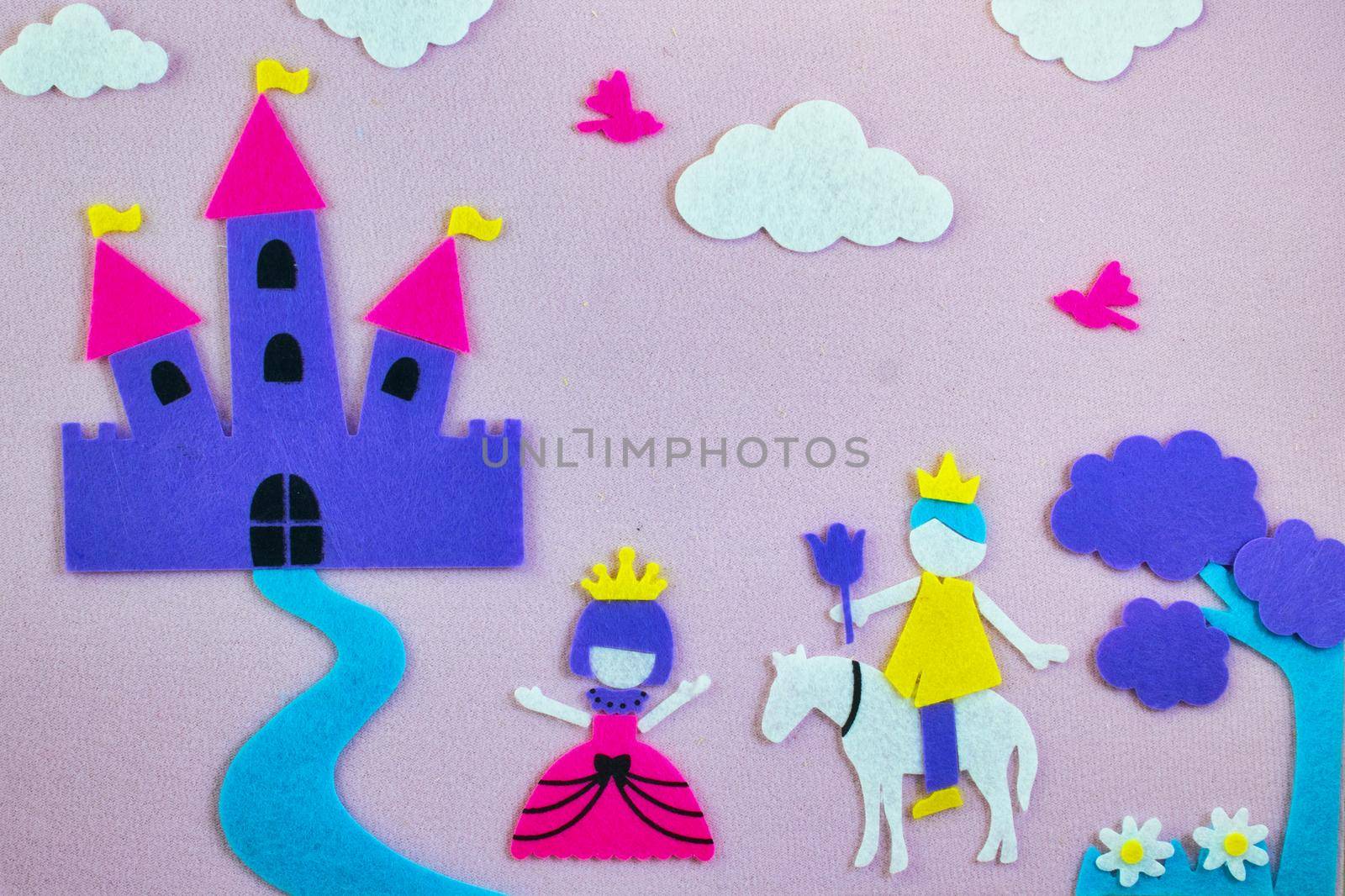 Cute fairy tale scene in felt with a princess and a prince in love in front of a fantasy castle